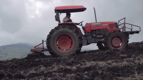 Red tractor plowing the earth 動画素材 75166862