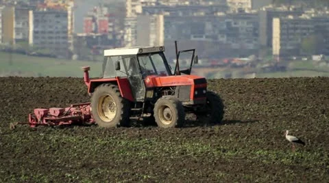 Red tractor plowing a field Stock Footage 22037760