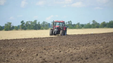 Red tractor plows a field Video stock 120448387
