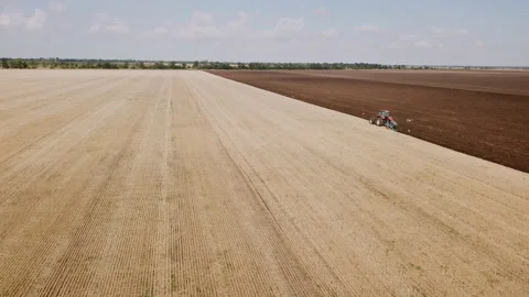 A red tractor plows a field Stock Footage 120449614