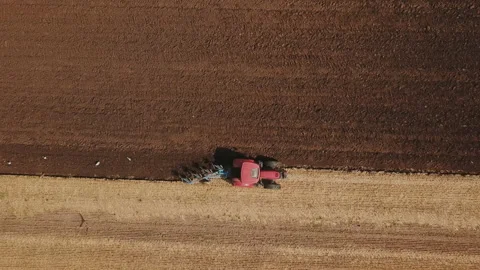 Red tractor plows the ground Stock Footage 125138161