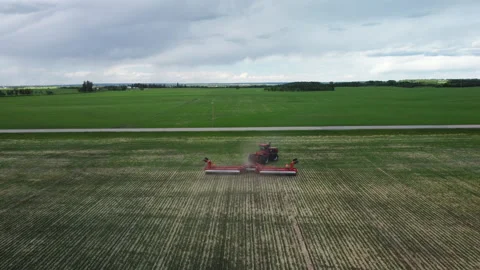 Red Tractor Pulling Roller Tracking from Behind Stock Footage 156472630