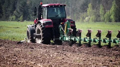 Red tractor with reverse plow plows heavy land, agricultural work in the field 스톡 동영상 131841353