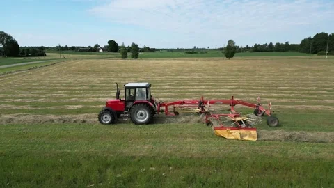 A-red-tractor-with-a-rotary-rake-12-2024-07-01-20-59-02-utc Stock Footage 278430938