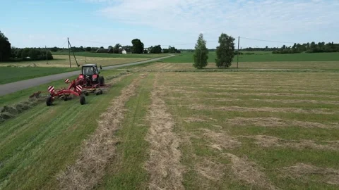 A-red-tractor-with-a-rotary-rake-14-2024-07-01-20-59-02-utc Stock Footage 278431691