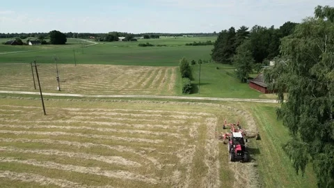 A-red-tractor-with-a-rotary-rake-4-2024-07-01-20-59-01-utc Stock Footage 278430624