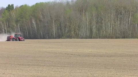 Red tractor with seeder working in the field. Video stock 279211228