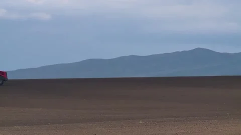 Red tractor sows the field with grain crops in the spring Stock-Footage 131445927