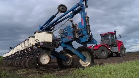 Red tractor sows the field with grain crops in the spring Stock Footage 131445939