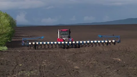 Red tractor sows the field with grain crops in the spring Stock-Footage 131445996