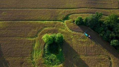Red Tractor Towing Blue Sprayer Tank With Extended Boom Across Field in 4k Stock Footage 341472367