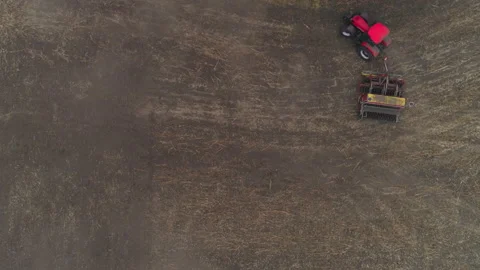 Red tractor turning around after seeding or hey field aeration Stock Footage 167551732
