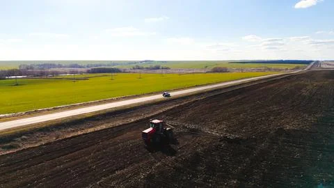 The red tractor works in the field in the spring Photos
