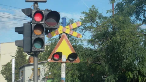 Red traffic light and flashing red lights signaling that a train is coming Stock Footage 296844640