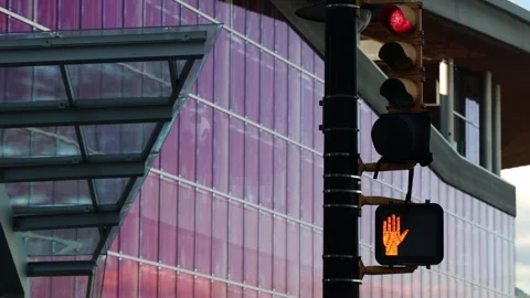 Red traffic light and pedestrian stop sign in front of glass skyscraper Stock Footage 342219749