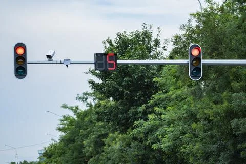 Red Traffic Light with Countdown Timer and Surveillance Camera on Urban Road Фото