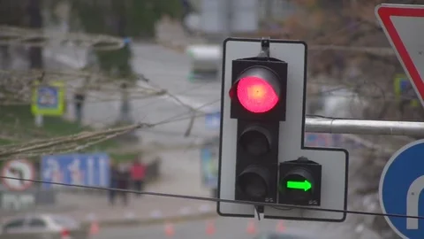 Red traffic light lights up against a background of moving cars on a city road Video stock 81716691