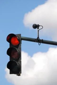 Red traffic light with sensor against cloudy sky Stock Photos