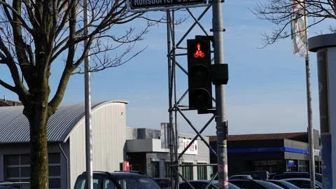 A red traffic light showing a pedestrian symbol against a clear blue sky. Vidéo 329384394