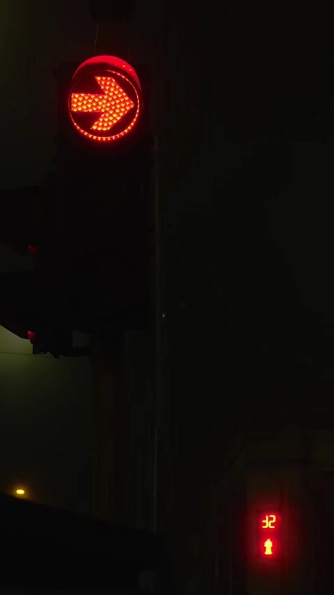 Red traffic light showing right arrow and countdown timer at night Video stock 312223412