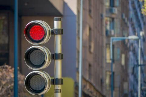 Red traffic light with timer in a blurred city background. City Street Traffic Stock Photos