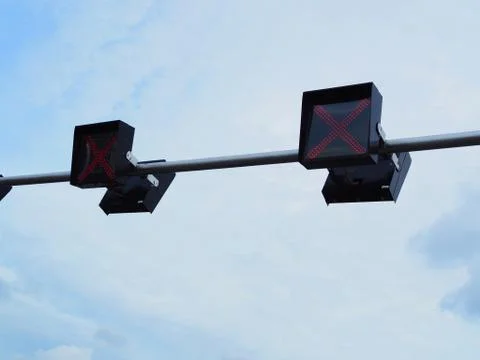 Red traffic stop X cross mark LED lamp floating, cloudy sky background Foto stock