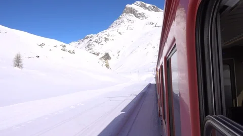Red train on Bernina Pass in Winter season Stock Footage 87673672