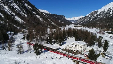 Red train of Bernina, train station of Morteratsch. Aerial view 4k Stock Footage 86792352
