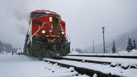 Red train engine pulling cargo in the snow Stock Photos