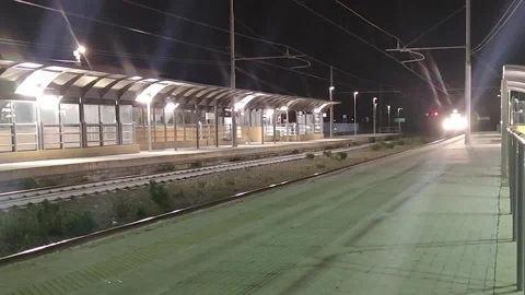 Red train at high speed passes the station. Tourists go to the sea to rest.  Stock Footage 197142581