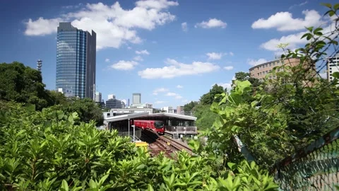Red train leaves the station. Blue clear sky in Tokyo Japan. Stock Footage 220110522
