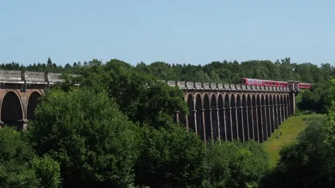 Red Train Moving Across The Arches Of A Picturesque Viaduct, England, 4K Vídeos de archivo 133280339