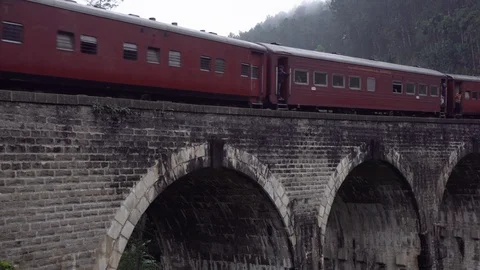 Red train pass over the famous 9 arch bridge in Ella, sri lanka. Stock Footage 107877331