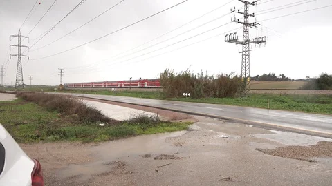 Red train passes through rural areas on a rainy day Stock Footage 99577169