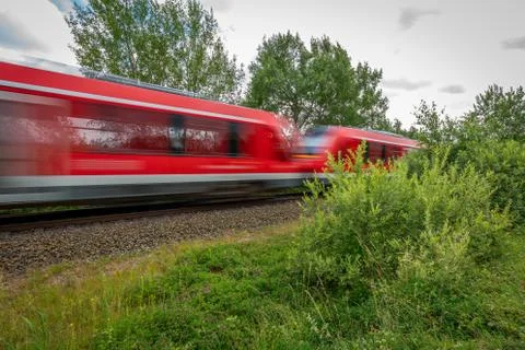 A red train races past a camera Stock Photos