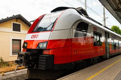 Red train standing in a station on a cloudy day Stock Photos