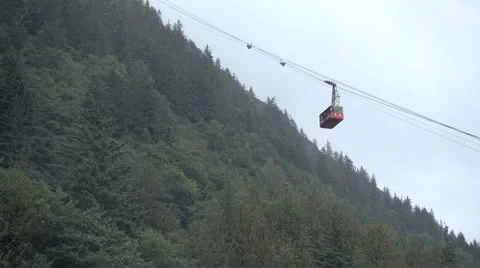 Red tram climbs mountain in rain from Juneau AK Stock Footage 66916630