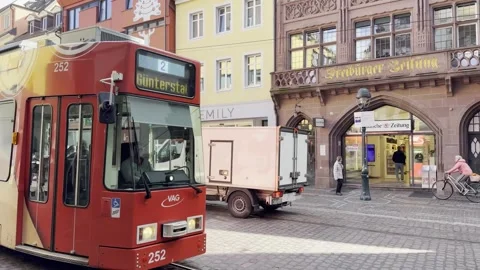 A red tram passes through the Martinstor in Freiburg, Germany 스톡 동영상 333946446