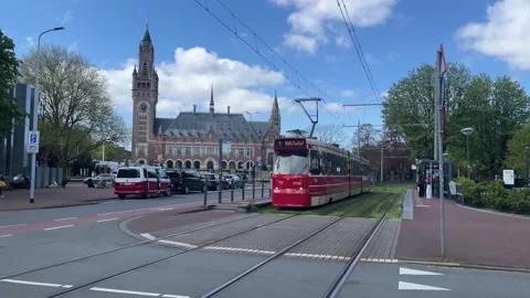Red tram stands at tram stop and departs from it Vidéo 331578620
