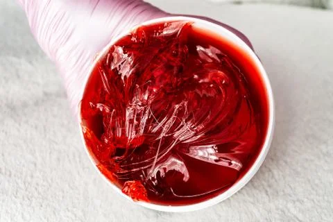 Red transparent shugaring paste in a white jar Stock Photos