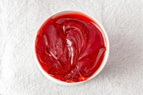 Red transparent shugaring paste in a white jar Stock Photos