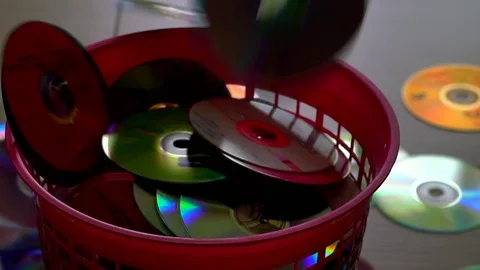 Red trash bin and falling DVD or CD Discs . Time lapse Video stock 76621354