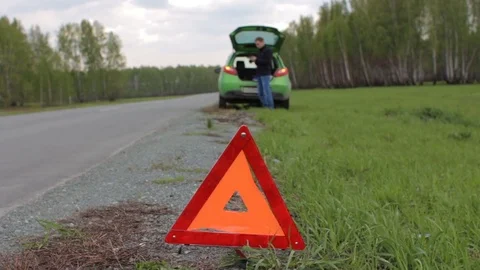Red triangle and broken car in rural area. Man talking on phone with assistant Stock-Footage 75920066