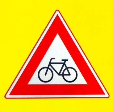 A red triangle beware of cyclists warning sign on a yellow background Stock Photos