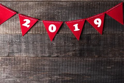 Red triangle flags hanging over wooden background with sign 2019 Stock Photos