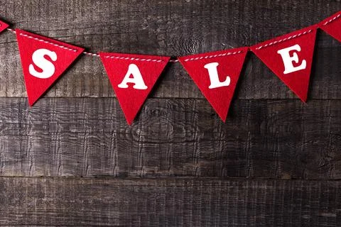 Red triangle flags hanging over wooden background with sign sale Stock Photos