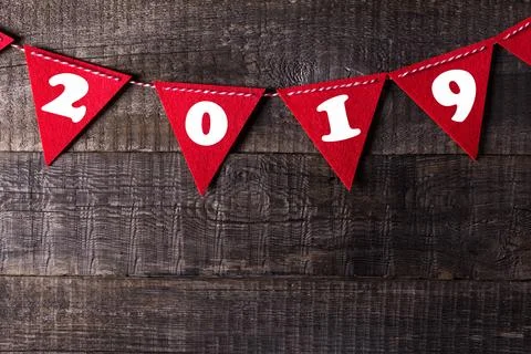 Red triangle flags hanging over wooden background with sign 2019 Stock Photos