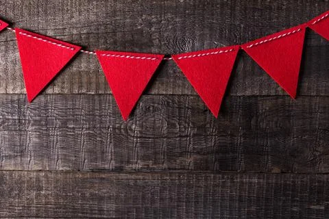 Red triangle flags hanging over wooden background Stock Photos