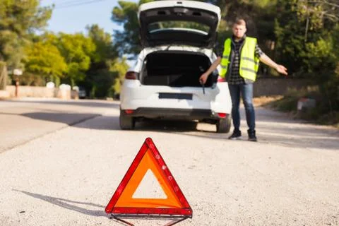 Red triangle man does not know what happened to the car Stock Photos