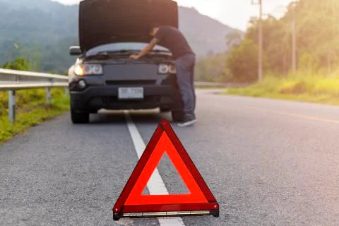 Red triangle sign on road for warning have car with breakdown open car hood a Stock Photos